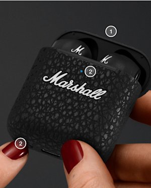 A hand holding an open Minor III charging case, while pushing the Bluetooth button on bottom of the case.
