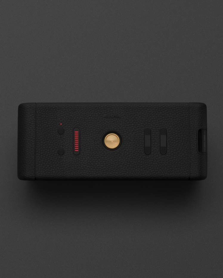 Un haut-parleur portable MIDDLETON BLACK AND BRASS avec un bouton rouge dessus.