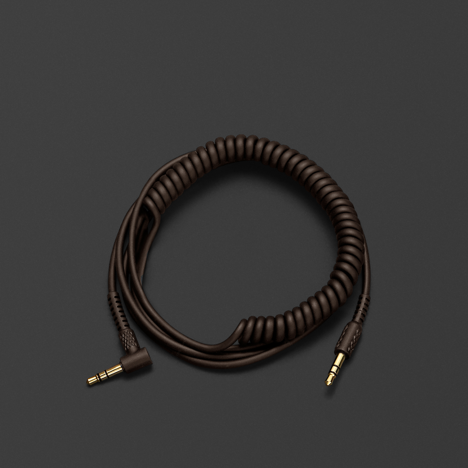 A brown coiled HEADPHONE AUDIO CABLE on a black surface. Brand Name: Marshall.