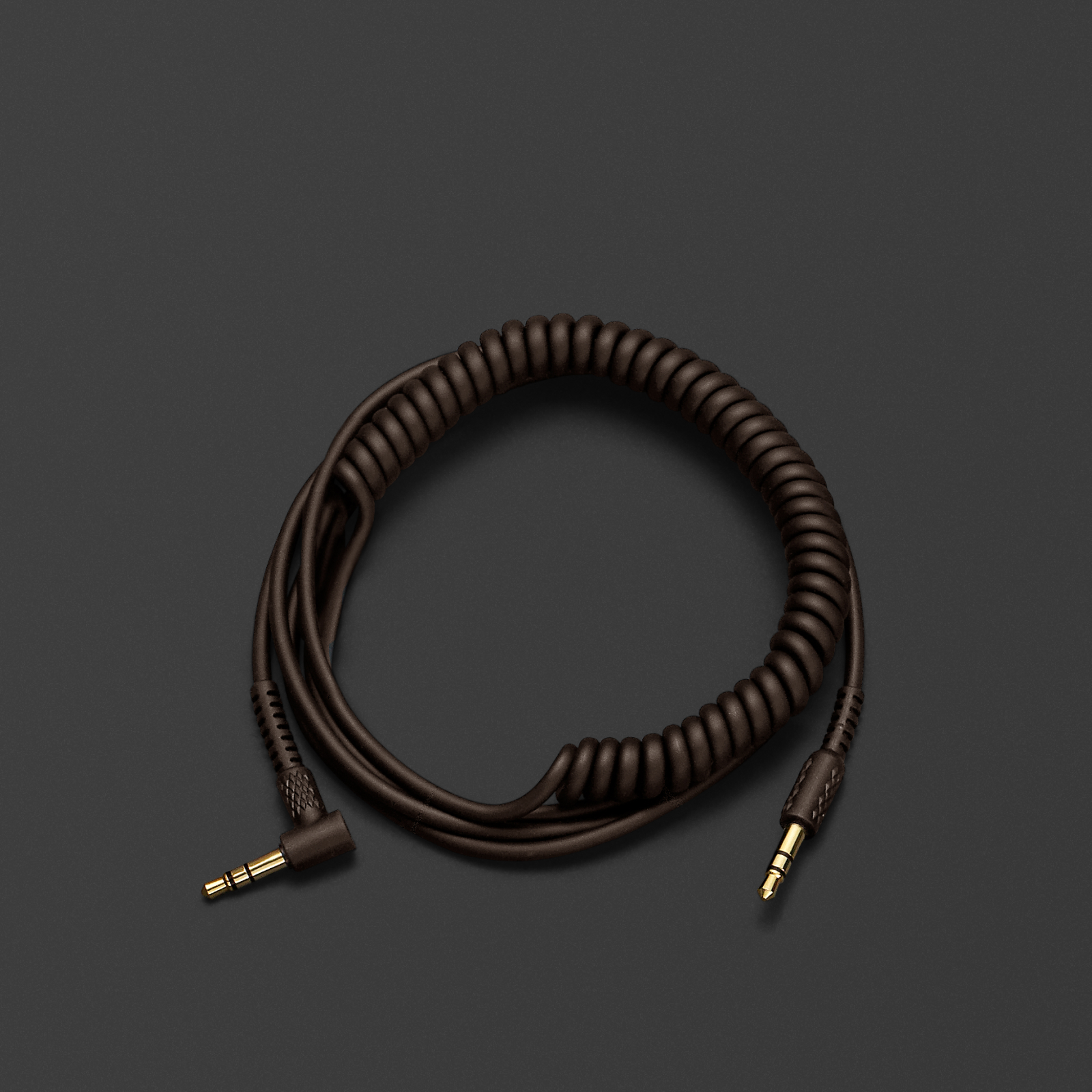 CABLE DE AUDIO PARA AURICULARES en espiral de color marrón sobre una superficie negra. Marca: Marshall.