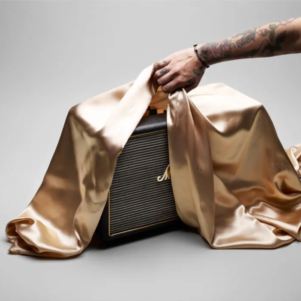 A Marshall speaker being unveiled from underneath a silk cloth