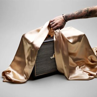 A Marshall speaker being unveiled from underneath a silk cloth
