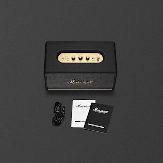 A black Marshall Stanmore III home speaker with mains lead, user manual and legal and safety information on a dark grey background.