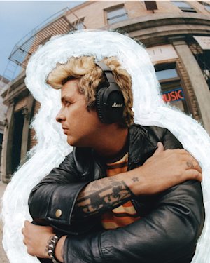 Billie Joe Armstong looking away wearing a Marshall over-ear headphone.