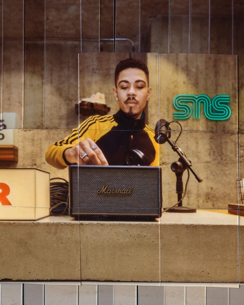 A young man adjusting the volume on a Marshall speaker at the SNS store in Stockholm, Sweden.