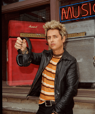 Billie Joe Armstrong holding his black Marshall over-ear headphones.