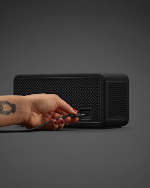 The USB-C port on the backside of a black Marshall Middleton II speaker.