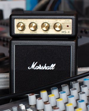 A musician playing guitar connected to the MS4 Micro Stack by Marshall