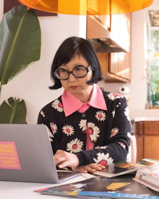 Shirley Kurata sits in front of a computer