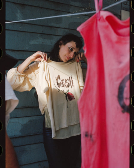 Zumi Rosow looking at a shirt hanging on a line.