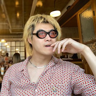 野DARK QUESTION wearing patterned shirt and round sunglasses.