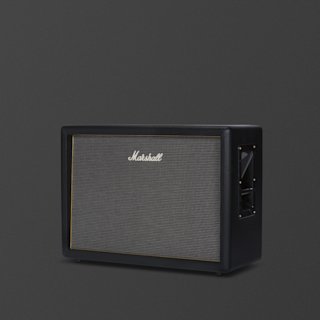 A black Marshall Origin212 guitar amplifier cabinet with a speaker grille, brass trim, and side handles, set against a plain dark background.