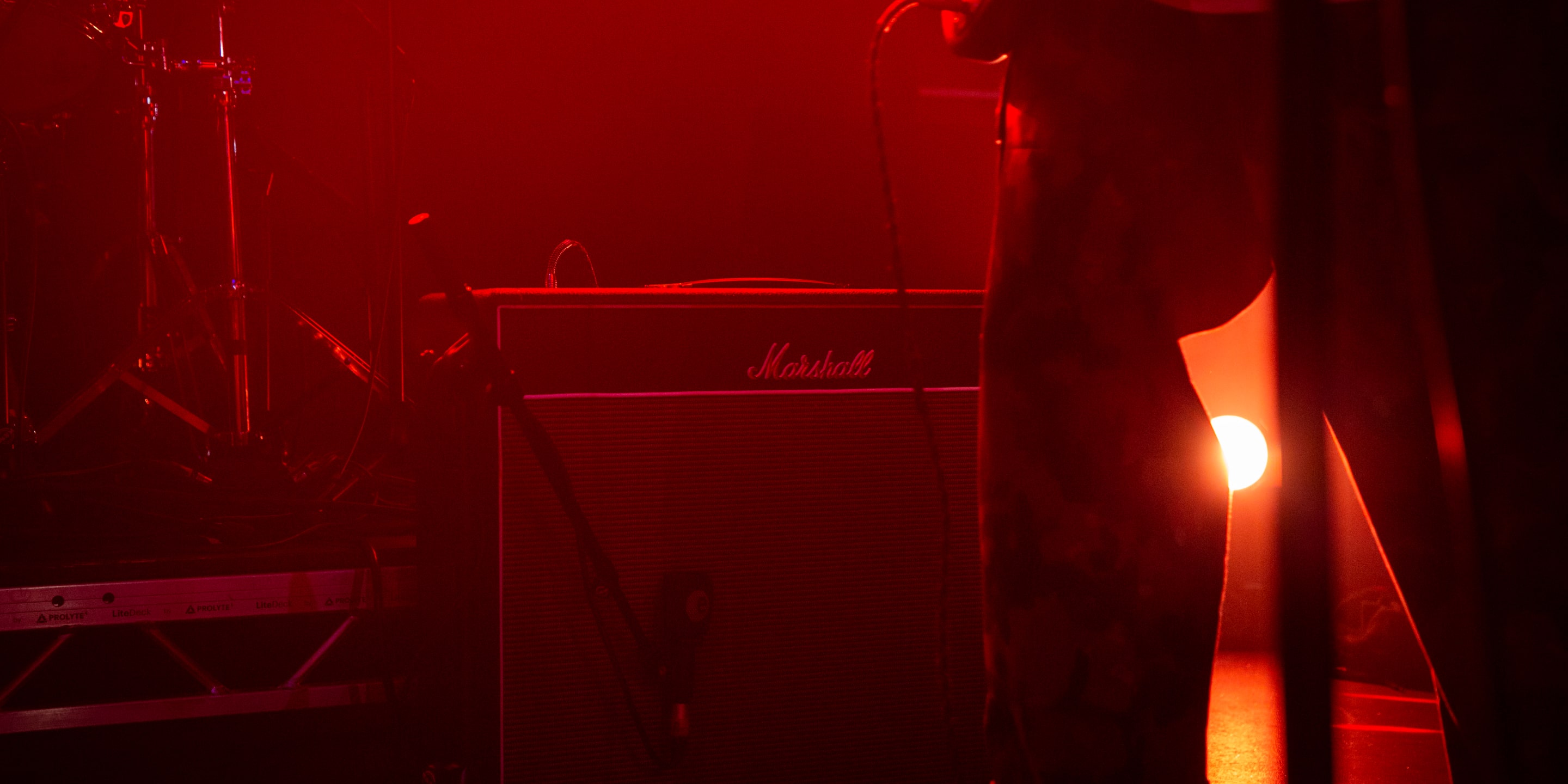 Un amplificateur Marshall Vintage Reissues sur une scène sous une lumière rouge.