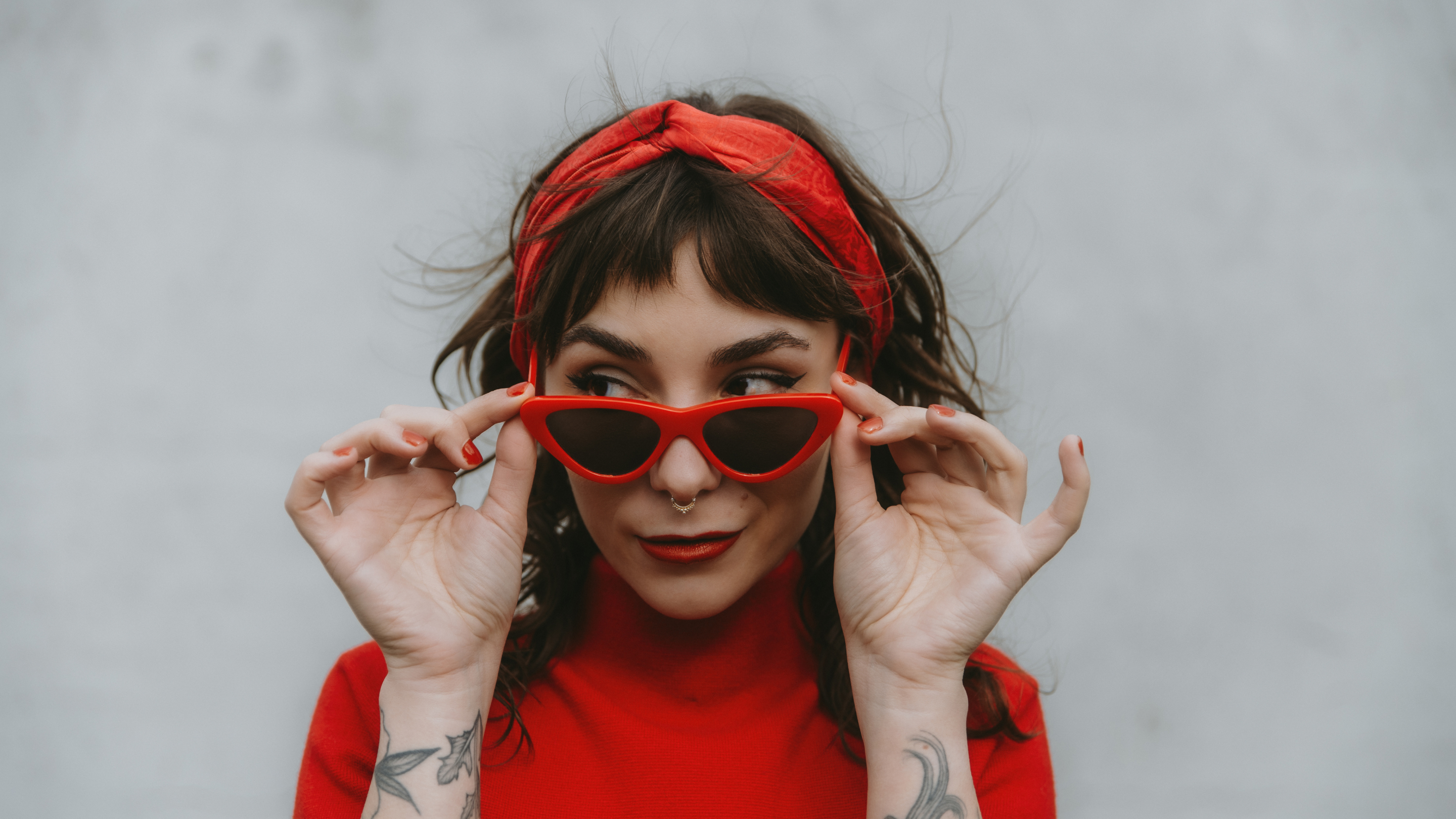 Gigi Gold looking over her red sunglasses