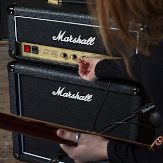 A musician turning up the Middle sound of the JVM 800