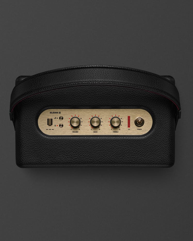 Marshall Kilburn III Black and Brass is a stylish portable speaker with a leather strap, control knobs for volume, bass, treble, plus power switch and indicator lights.