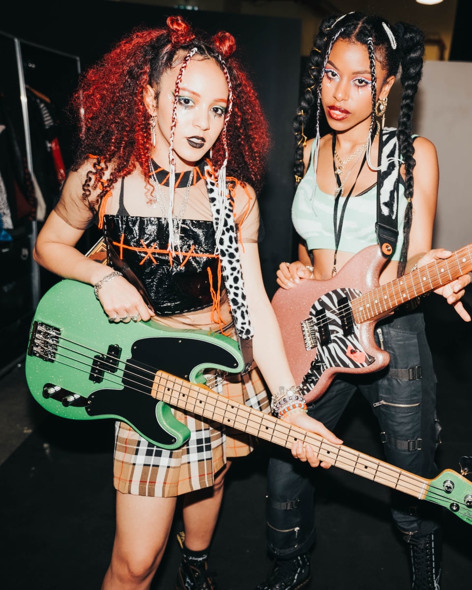 Las gemelas Nova posando con una guitarra verde.