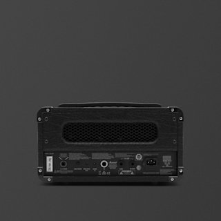The back view of a black Marshall DSL1 guitar amplifier head shows various input/output ports, a power switch, a mesh ventilation panel, and labeled controls against a dark background.