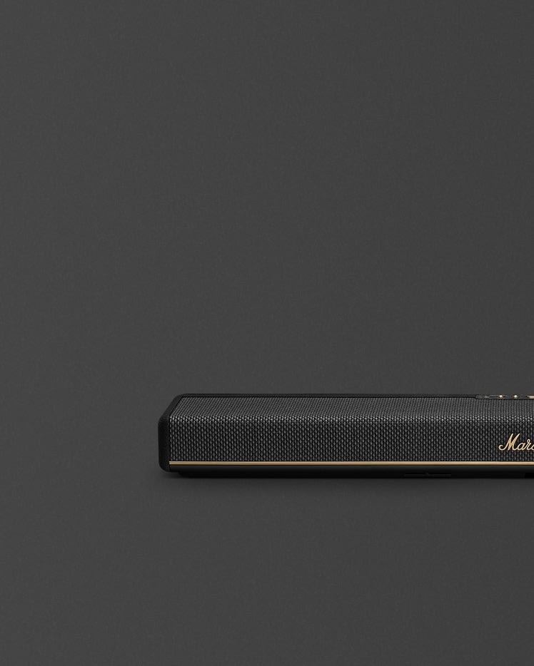 Marshall Heston 60 Black soundbar with a mesh front, is positioned in the lower right corner against a plain dark gray background.