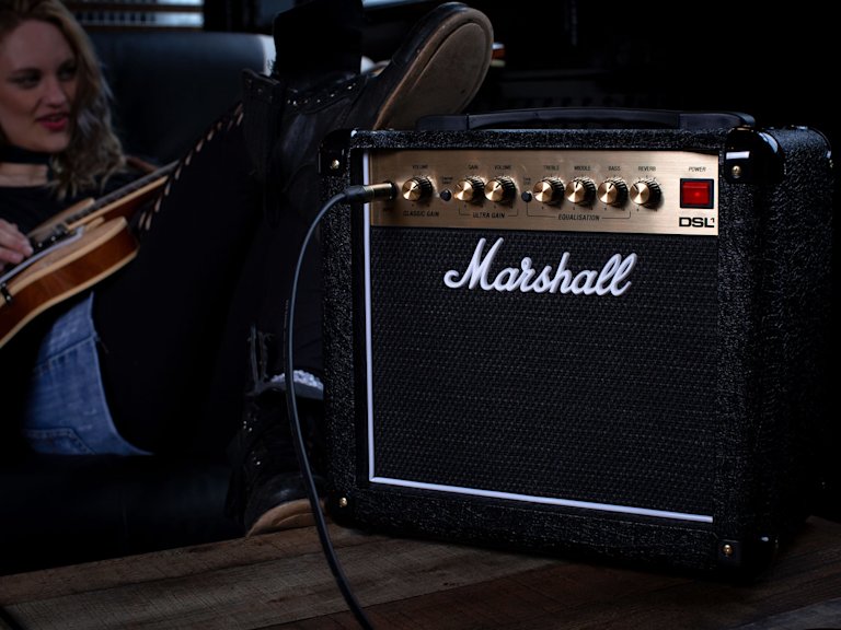 Una mujer tocando la guitarra con el Marshall DSL1 Combo