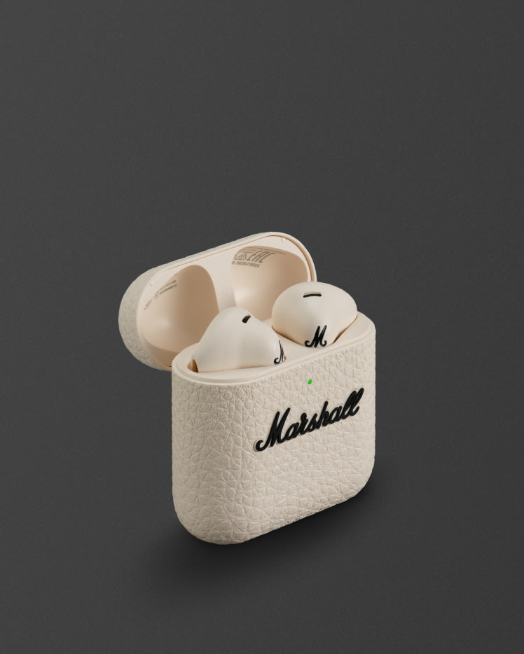 Une paire d'écouteurs intra-auriculaires sans fil Minor IV Cream avec un étui de chargement assorti arborant le logo Marshall.