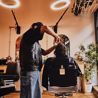 Un barbero corta el pelo a sus clientes en el Welcome Studio.