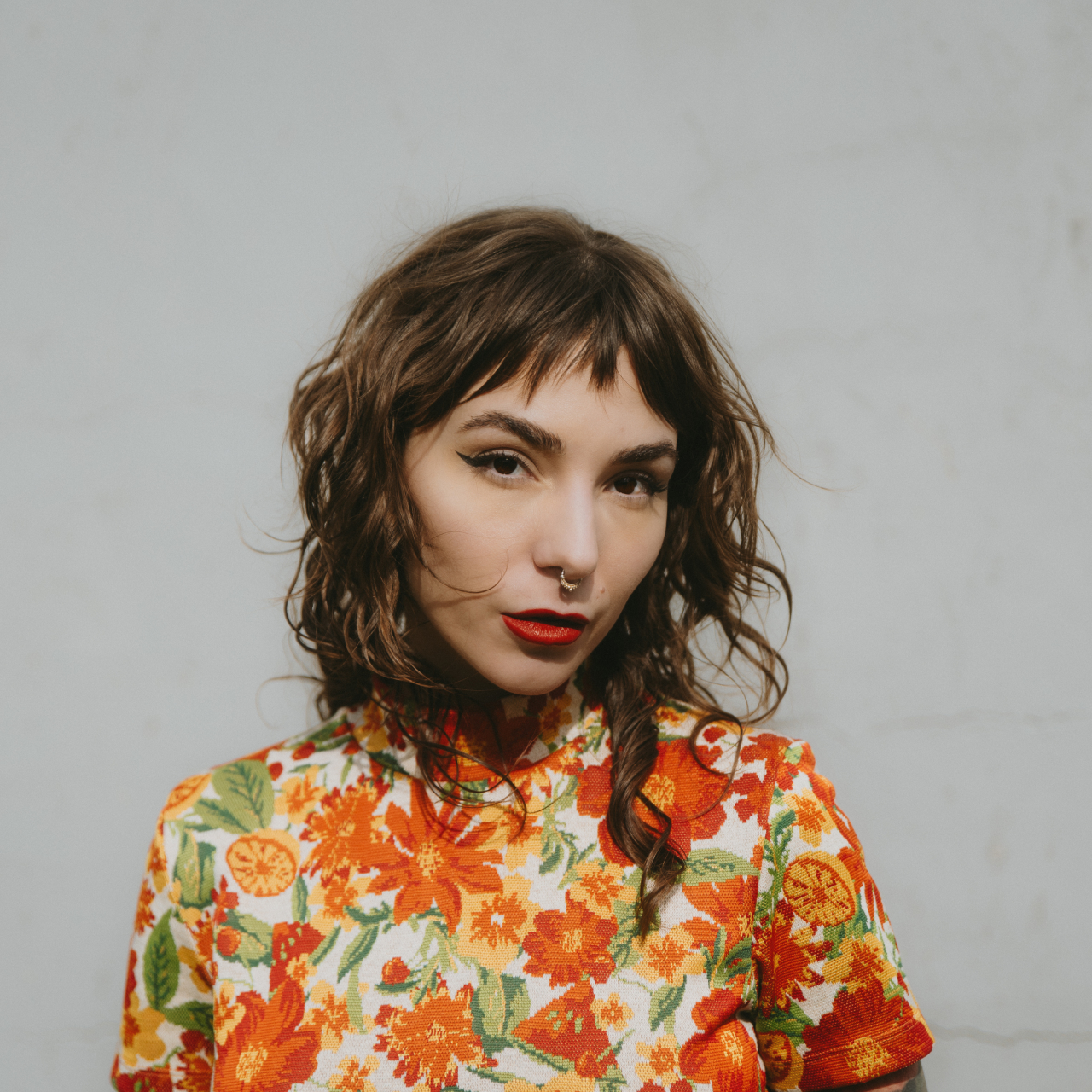 Gigi Gold wearing an orange flower shirt. 