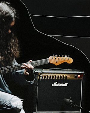 A long haired musician playing with the Marshall Studio 900