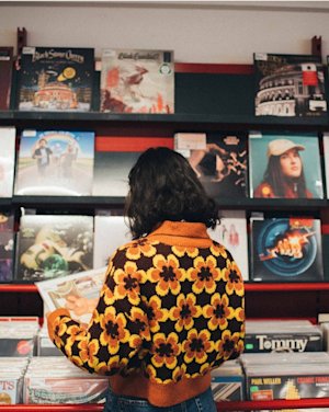 A person looking at vinyls in a record store.