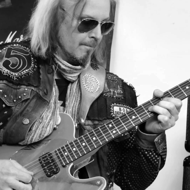 John 5 con gafas de sol tocando la guitarra