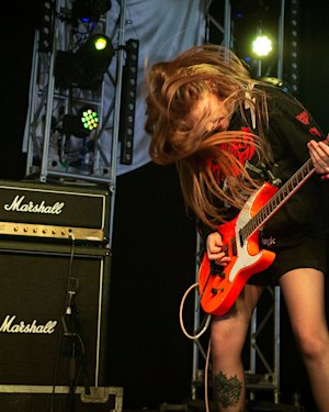 A woman playing guitar connected to the Marshall JCM800 2203 Vintage Reissue Head
