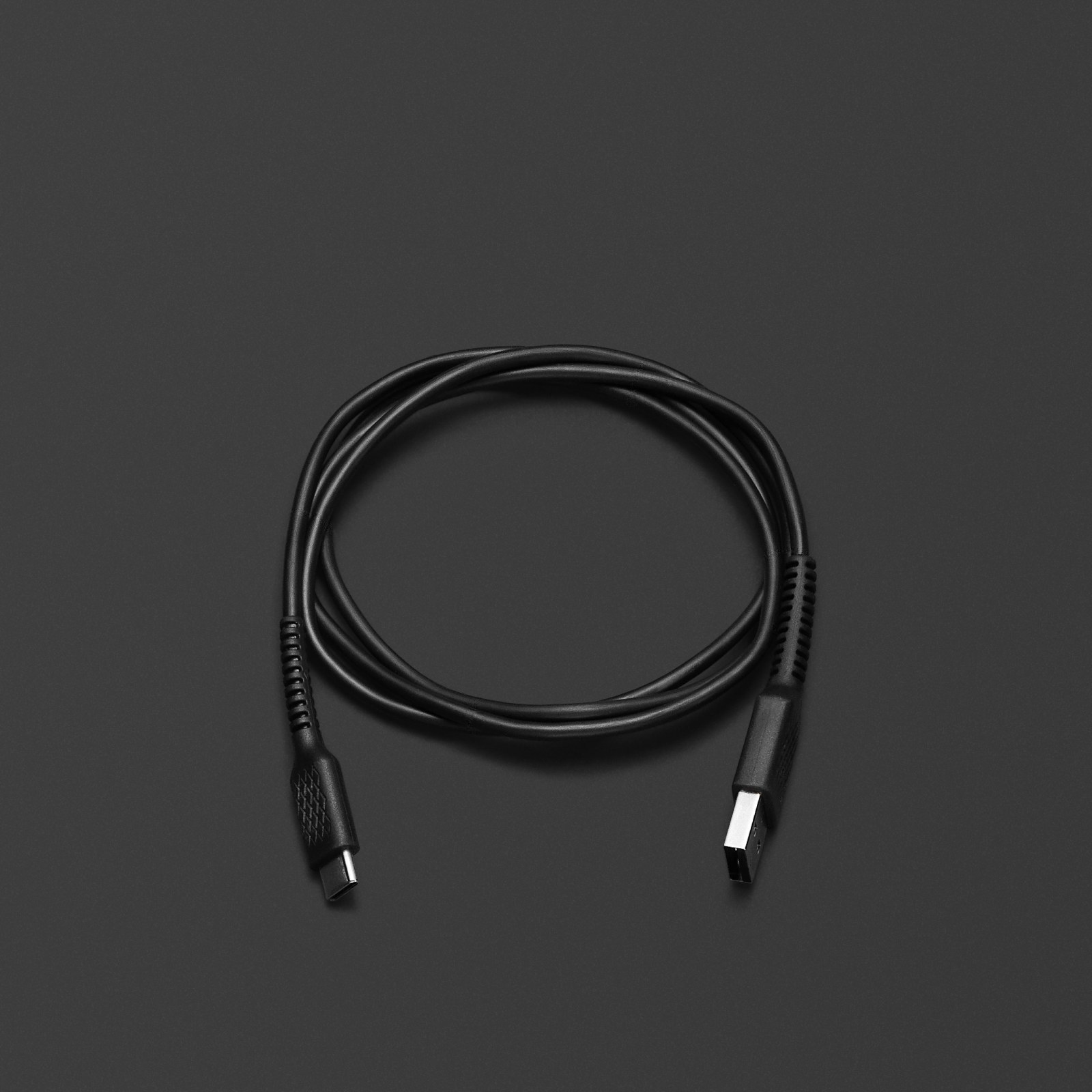 검은색 표면 위에 놓인 블랙 색상의 Marshall USB-C LONG CHARGING CABLE. 