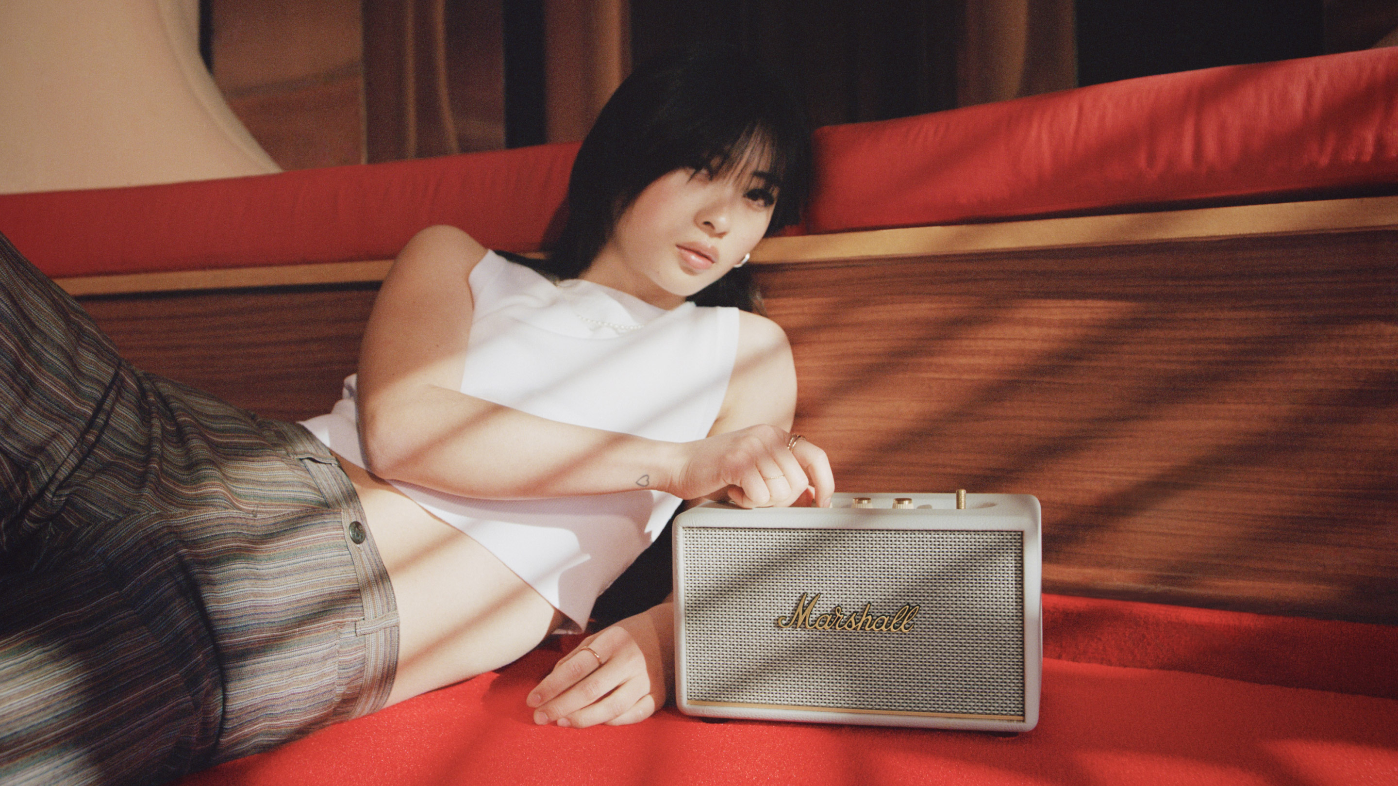 Girl increasing the volume of Marshall Cream Speaker