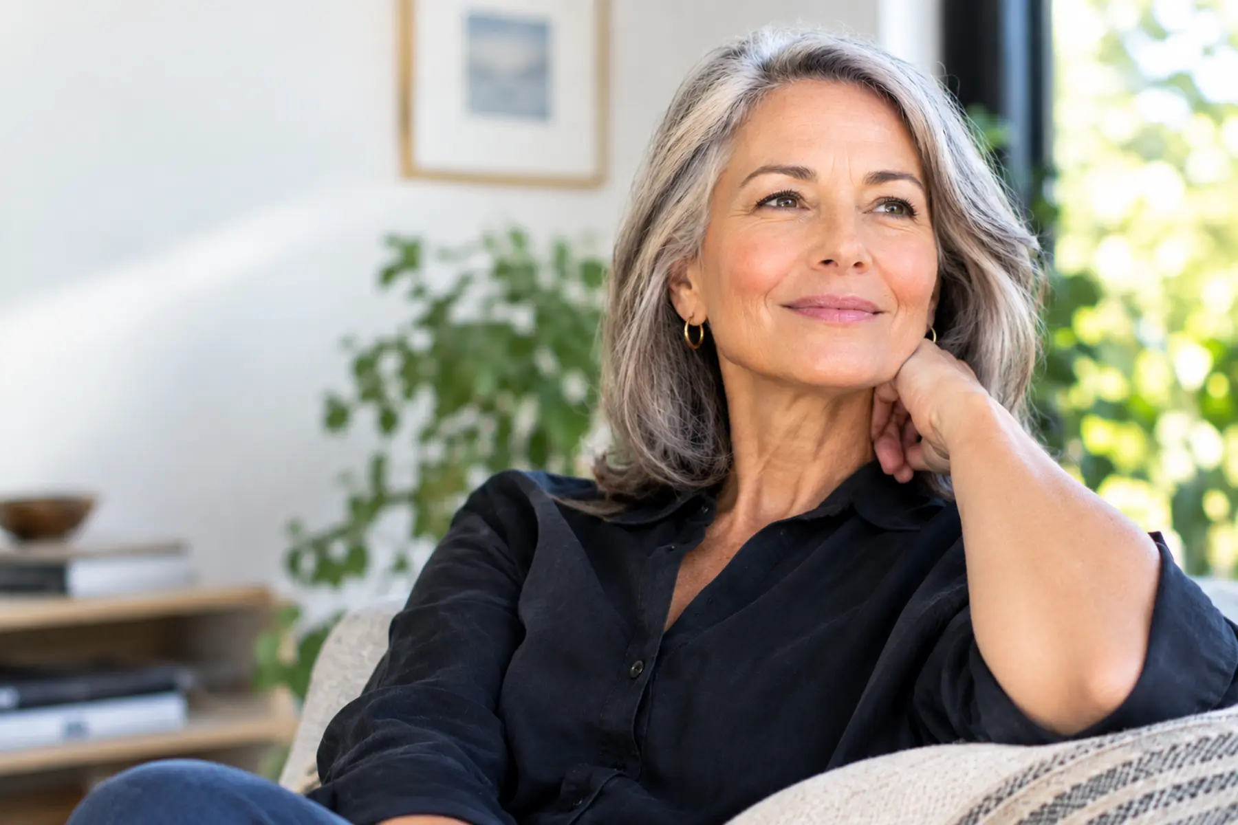 Woman in midlife looking confidently out the sunny window