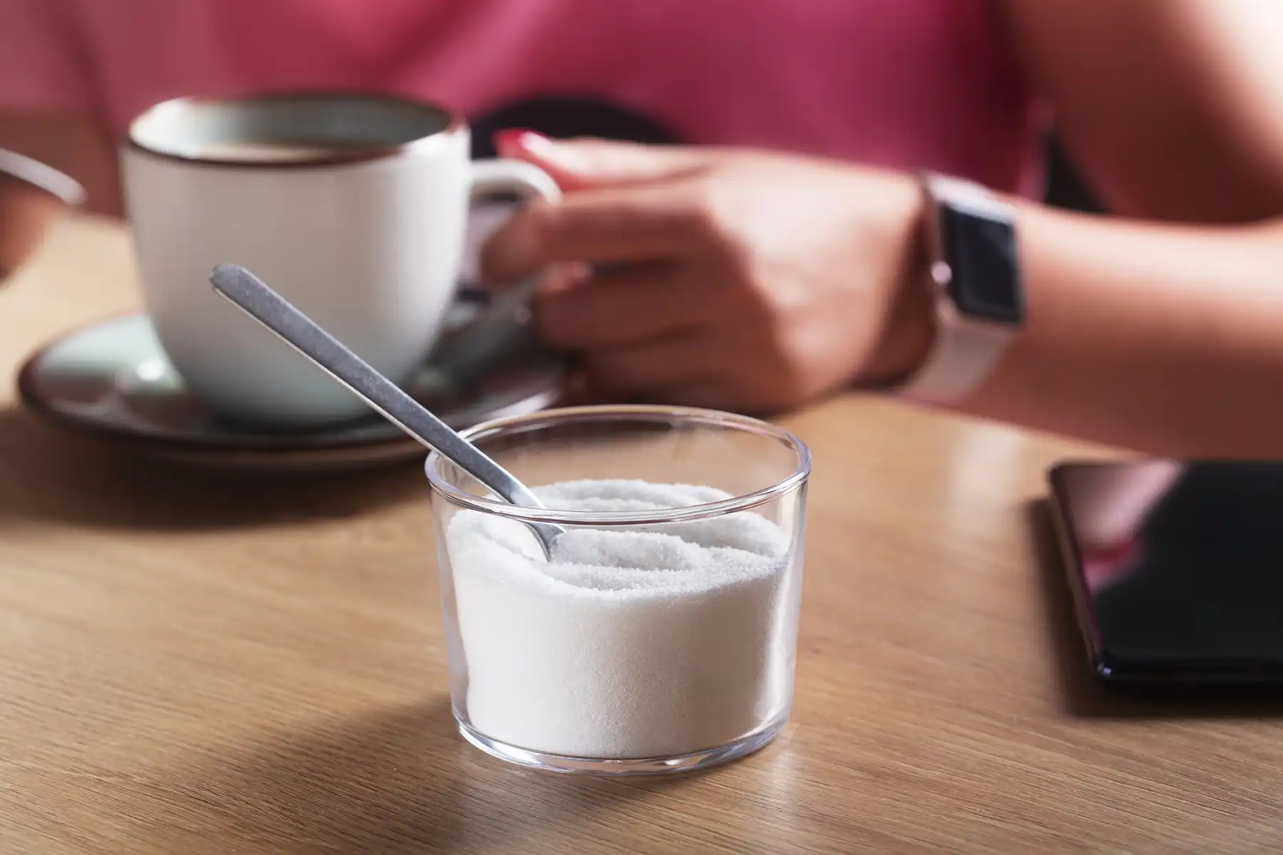 A cup of aspartame with a scooping spoon.
