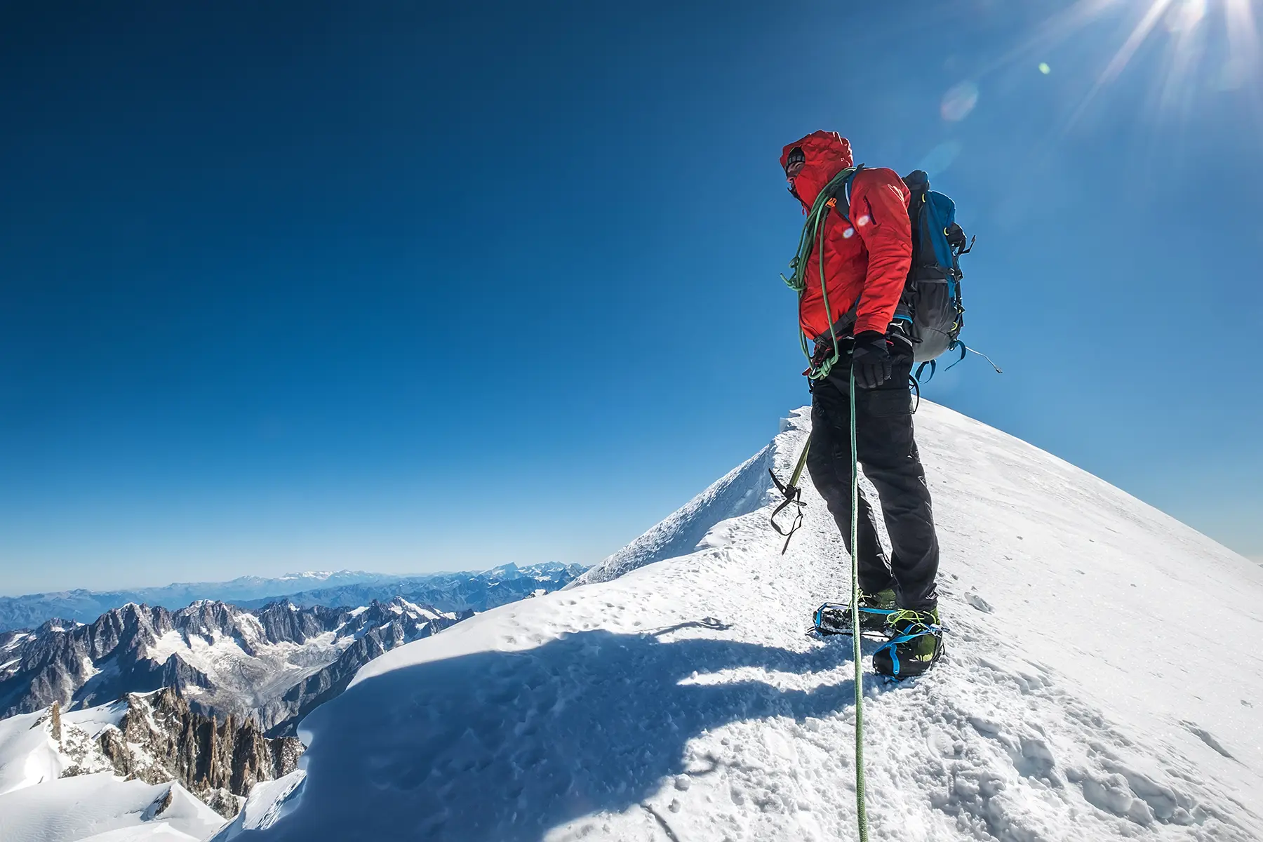 Male hiker at the top of a snowy mountain.