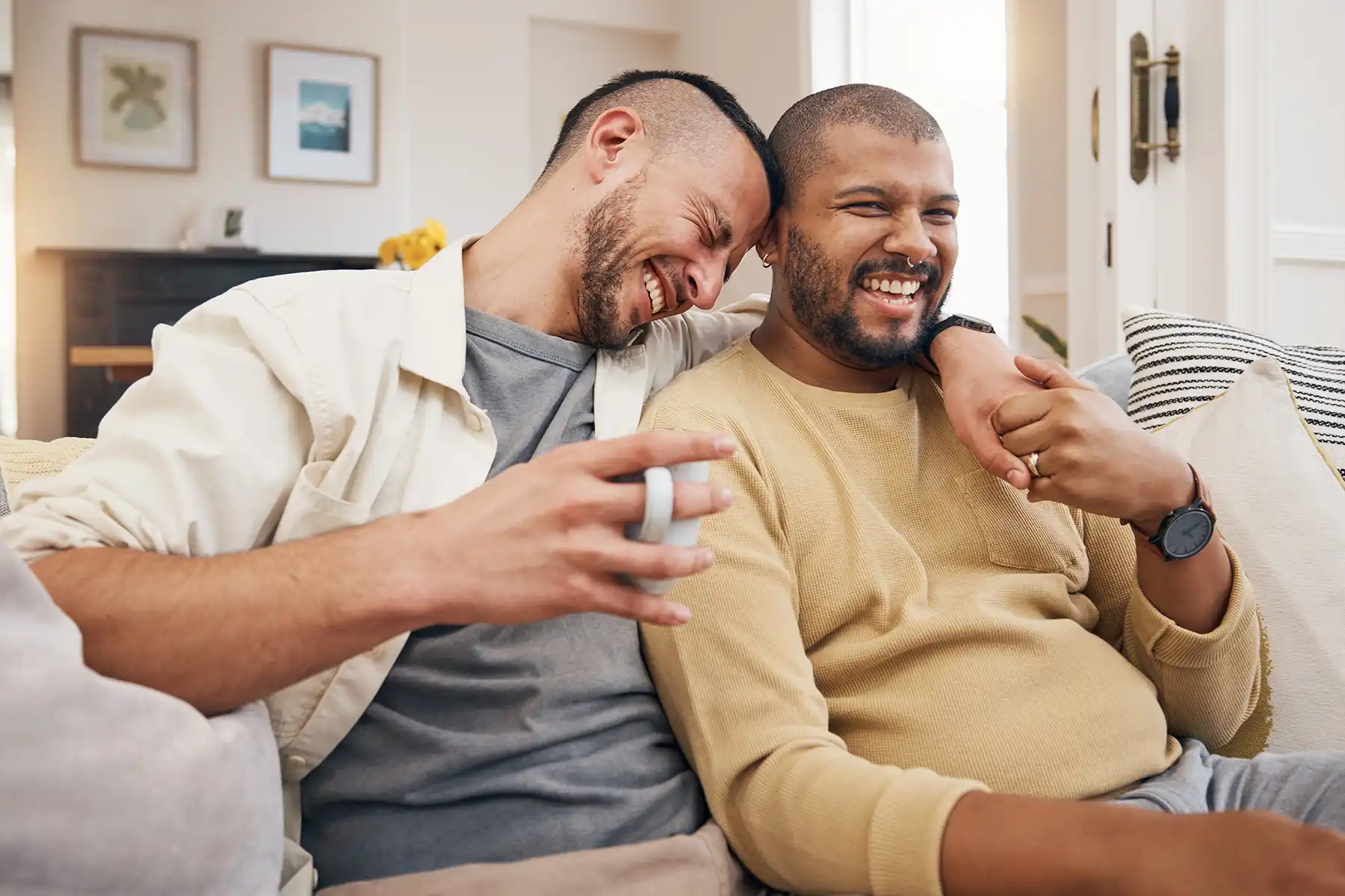 Two guys sitting on a couch laughing