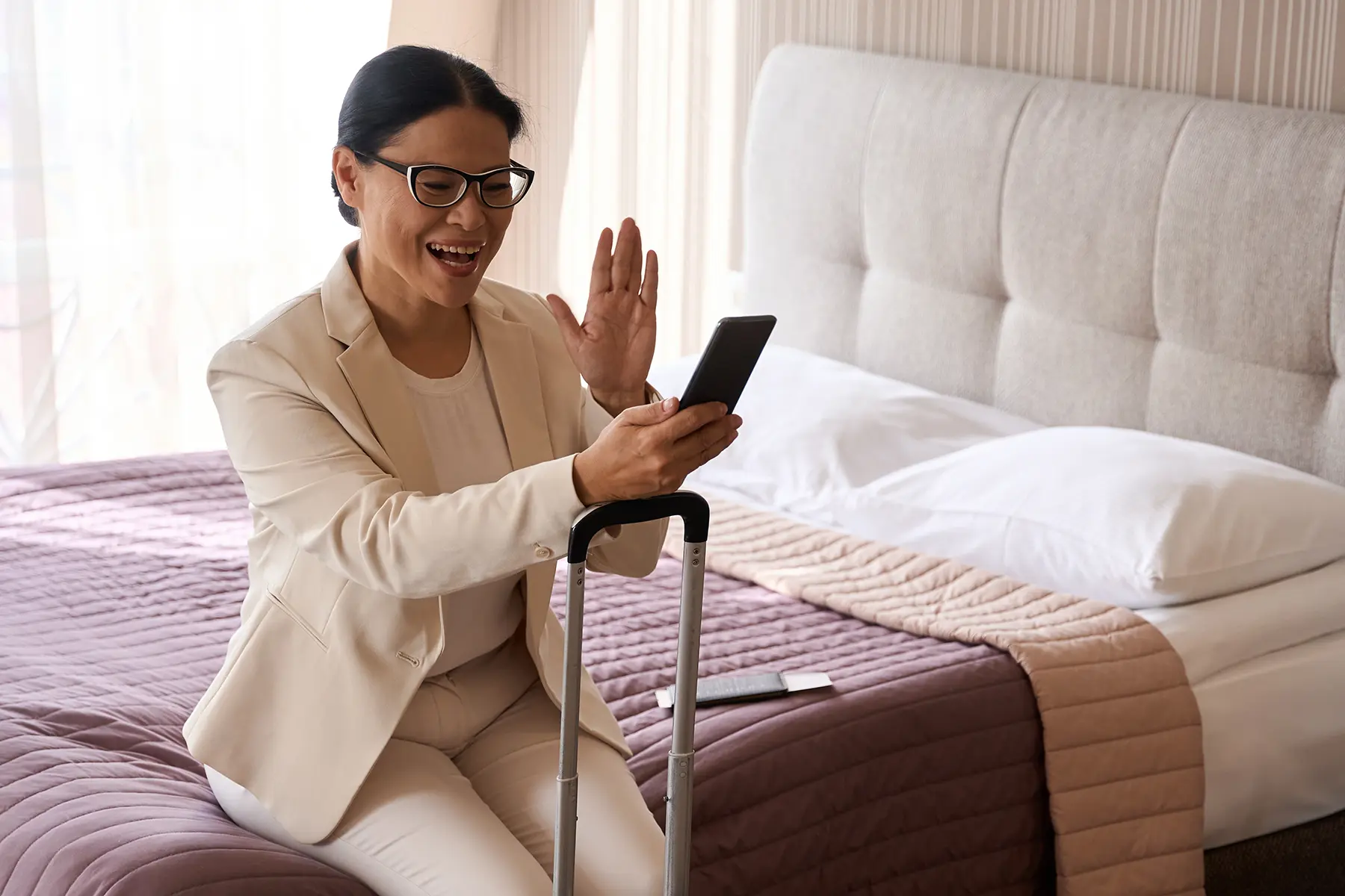 Woman in hotel room meeting with her doctor via video call