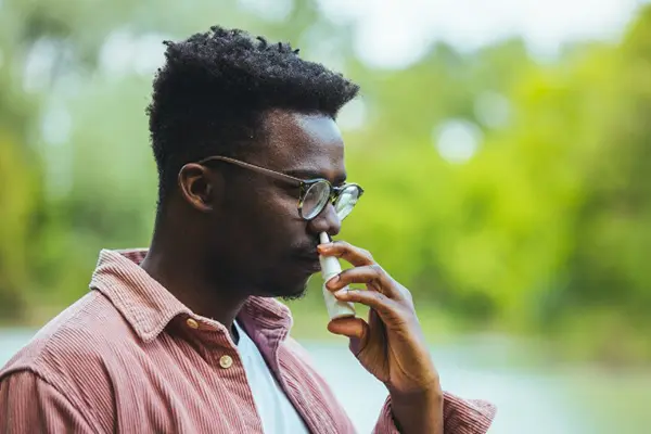 Man using nasal spray.