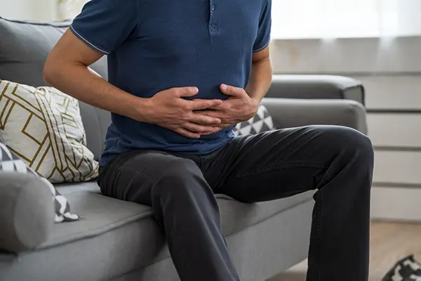 A man holds his stomach in pain.