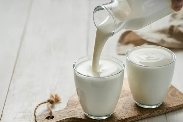 Kefir is poured into a glass.