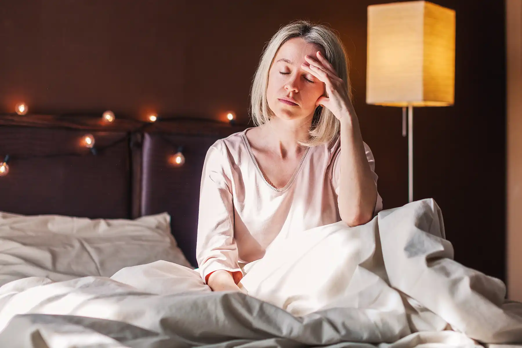 Frustrated woman getting out of bed after a sleepless night.