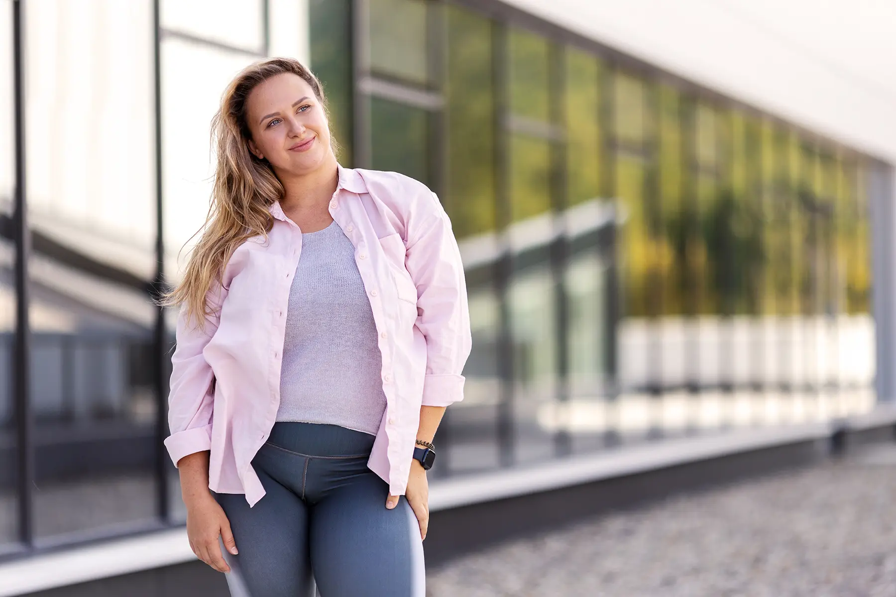 Woman standing outdoors and smiling.