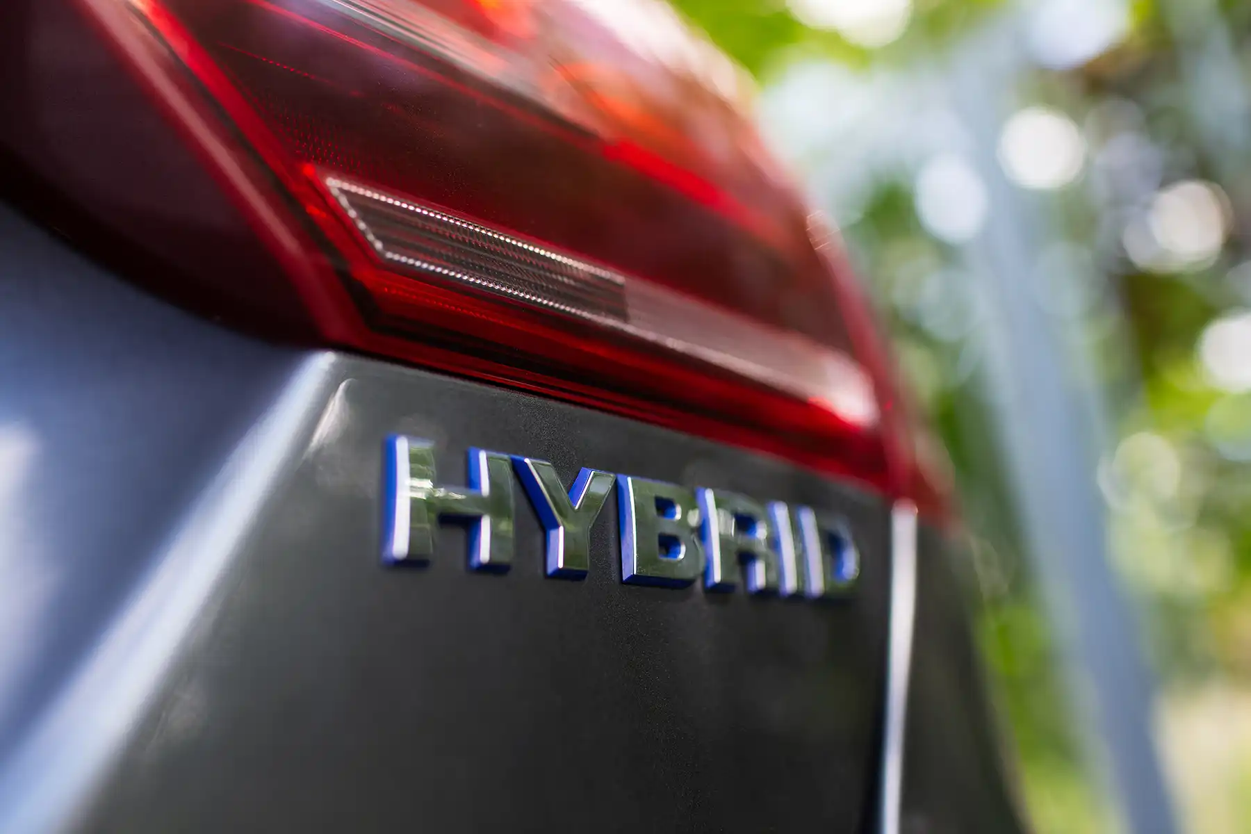 Close up of HYBRID on a gray car.