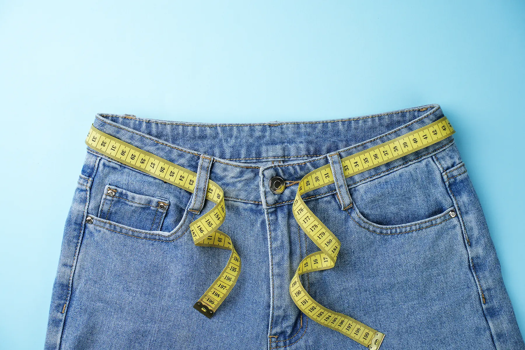 Jeans with tape measure looped through belt loops