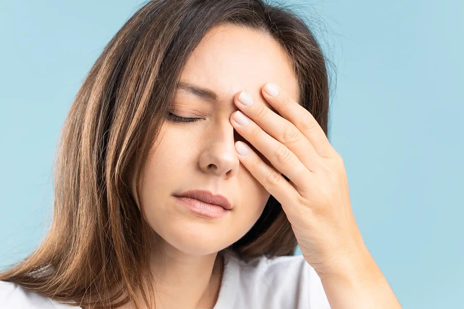 A woman covering her left eye