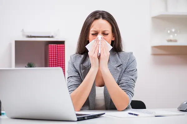 Woman blowing her nose.