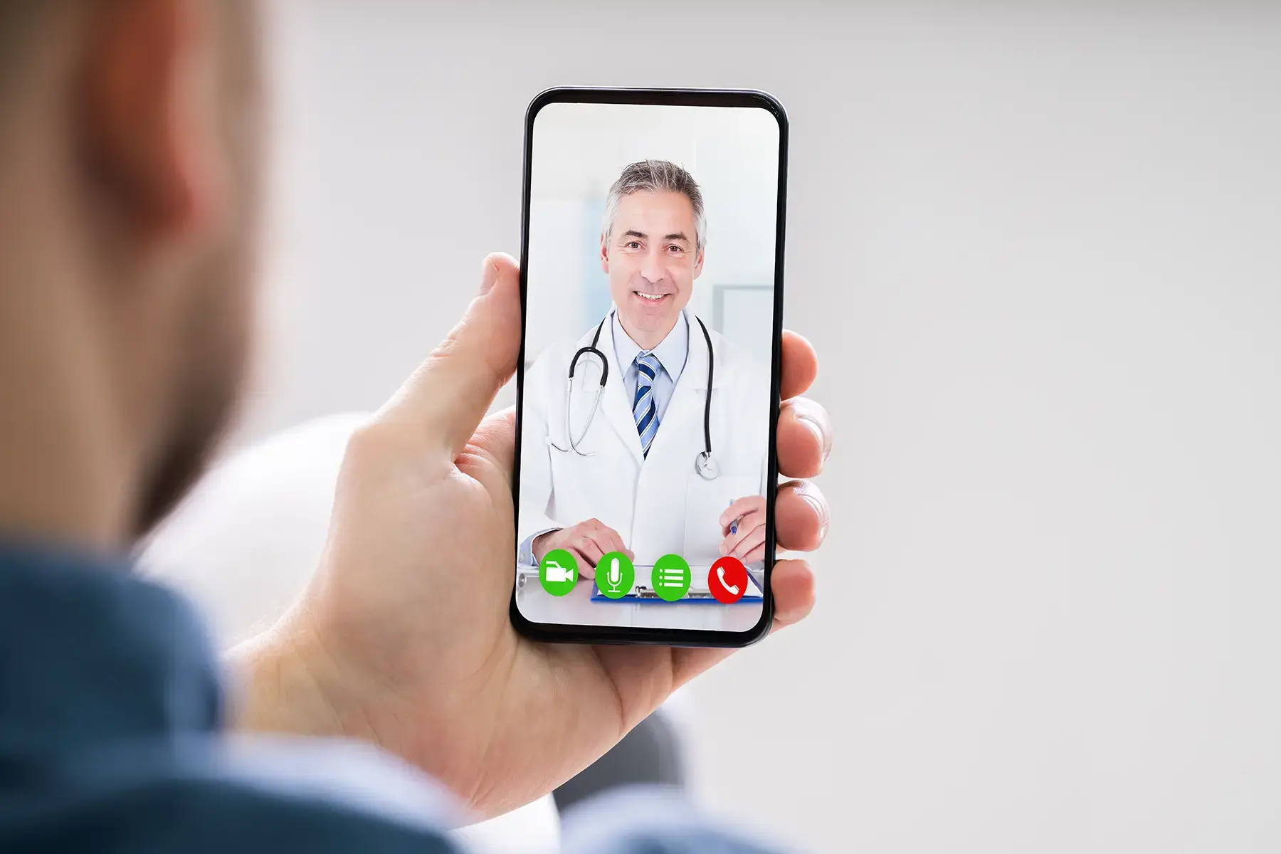 Man holding phone while on virtual call with his provider
