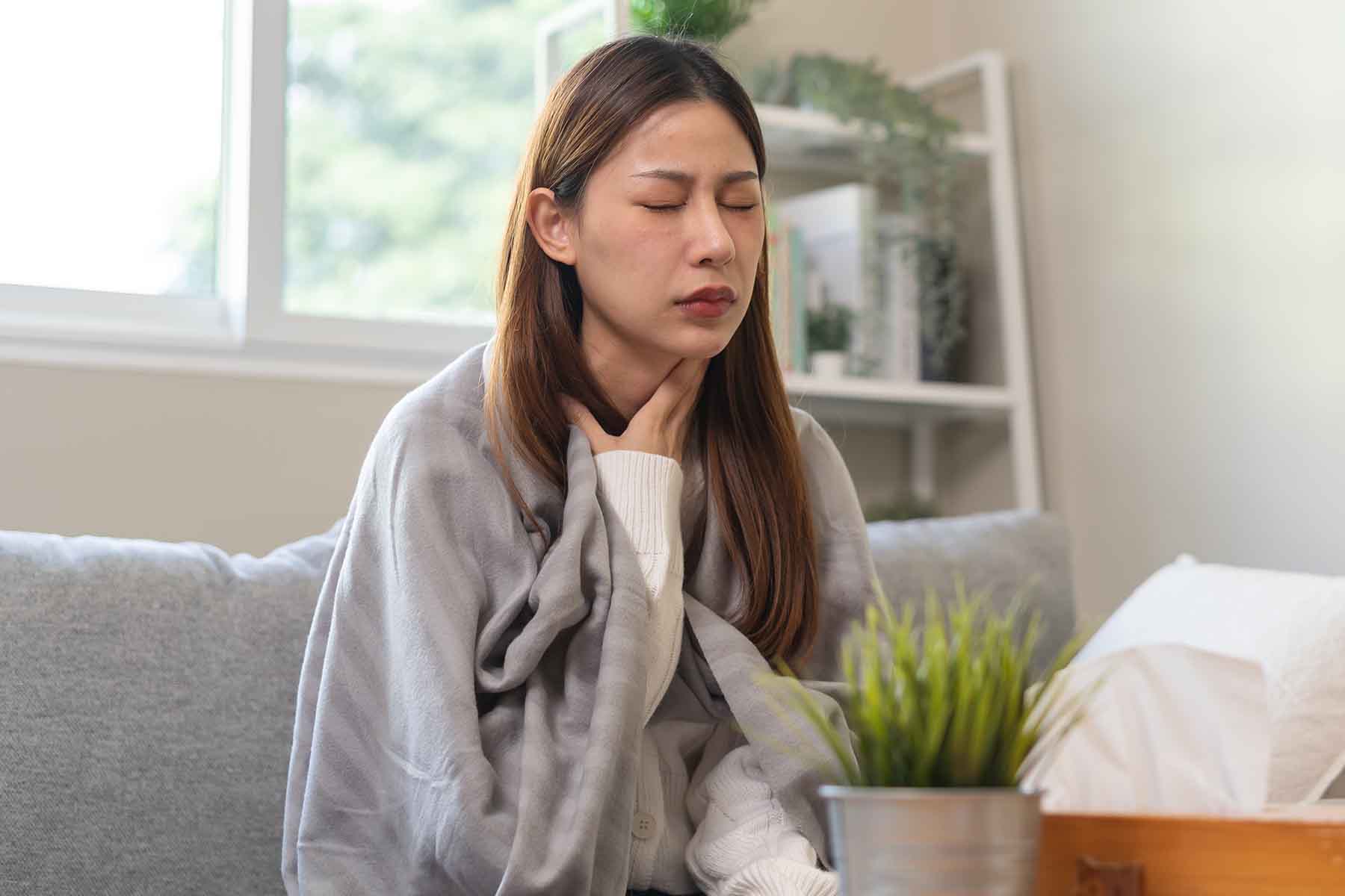 A woman experiencing a sore throat