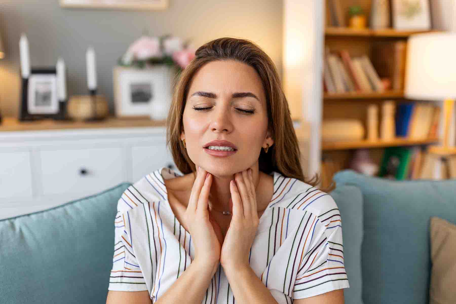 A woman gently touching her neck